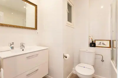 a white bathroom with a toilet and a sink at Cozy Apartment near Fira Gran Via with AC in Hospitalet de Llobregat