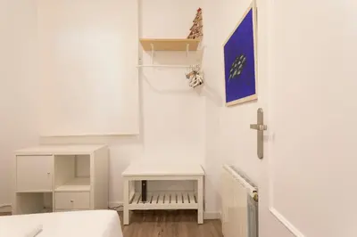 a white room with a bed and a table at Cozy Apartment near Fira Gran Via with AC in Hospitalet de Llobregat