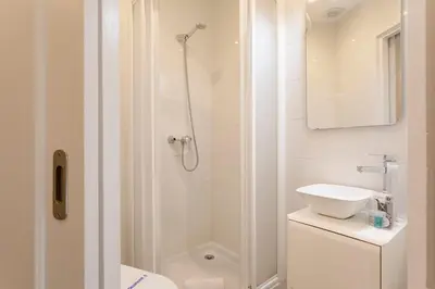 a white bathroom with a shower and a sink at Cozy Apartment near Fira Gran Via with AC in Hospitalet de Llobregat