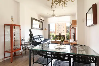 a living room with a glass table and chairs at Cozy Apartment near Fira Gran Via with AC in Hospitalet de Llobregat