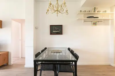 a dining room with a glass table and chairs at Cozy Apartment near Fira Gran Via with AC in Hospitalet de Llobregat