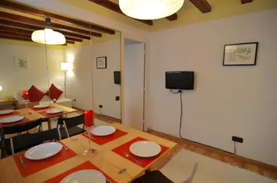 a dining room with two tables and a tv on the wall at Central Apartment in Barcelona