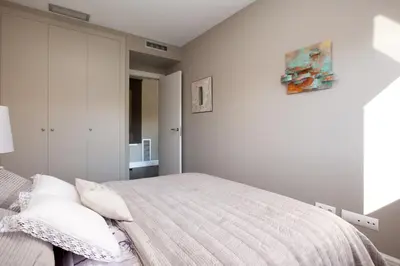 a white bedroom with a bed with white pillows at Calabria Luxury in Barcelona