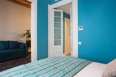 a blue bedroom with a bed and a blue couch at Trafalgar Luxury in Barcelona