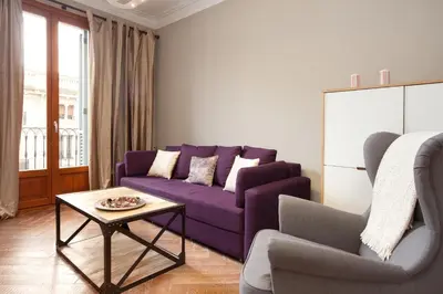 a living room with a purple couch and a table at Trafalgar Luxury in Barcelona