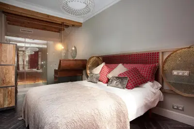 a bedroom with a large bed with red pillows at Trafalgar Luxury in Barcelona
