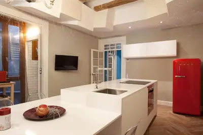 a kitchen with a white counter and a red refrigerator at Trafalgar Luxury in Barcelona