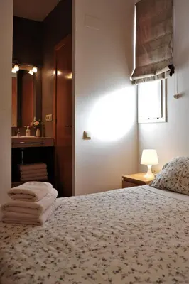 a bedroom with a bed with towels on it at Apartamentos Bejar in Barcelona