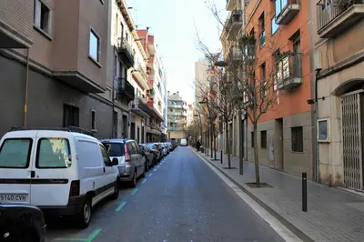 a street with cars parked on the side of the road at Apartamentos Bejar in Barcelona