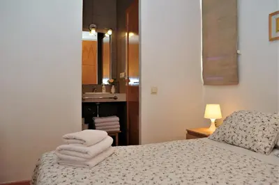 a bedroom with a bed with towels on it at Apartamentos Bejar in Barcelona