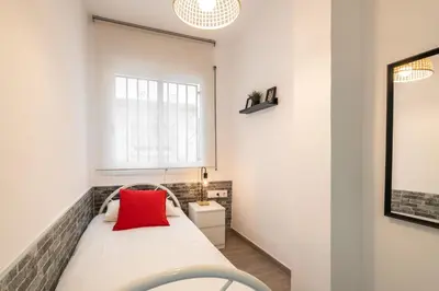 a bedroom with a bed with a red pillow on it at Beach Apartment, next to the sea in Premiá de Mar