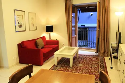 a living room with a red couch and a table at Apartaments St. Jordi Comtal in Barcelona