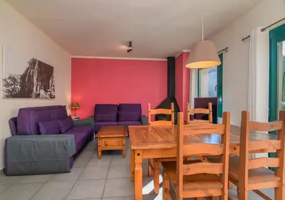a living room with a purple couch and a table at Apartaments Rural Montseny in gualba de Dalt