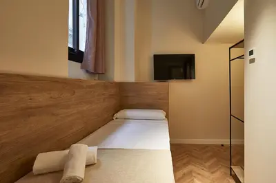 a small room with a bed and a tv at Ella Hostel Boqueria in Barcelona
