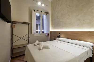 a bedroom with a bed with towels on it at Ella Hostel Boqueria in Barcelona