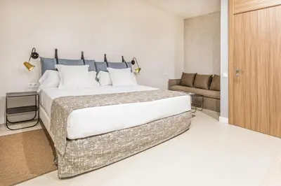 a bedroom with a large bed and a couch at Casa Lirio in Barcelona