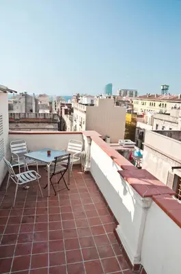 a patio with a table and chairs on a balcony at Barceloneta Suites Apartments Beach in Barcelona