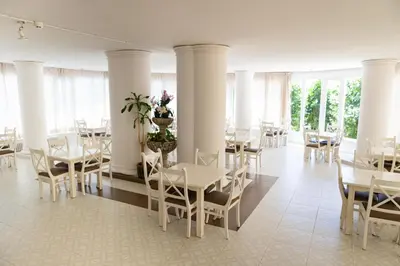 a dining room with white tables and chairs at Hotel Haromar in Calella