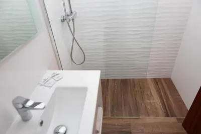a bathroom with a shower and a white sink at Hotel Haromar in Calella