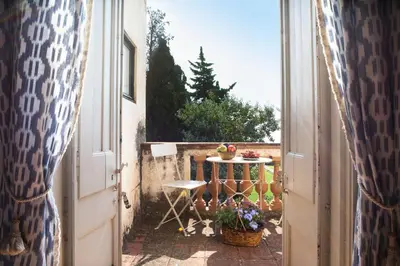 an open door to a patio with a table and a chair at B&B Can Casadella in Premia de Dalt