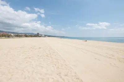 a beach with footprints in the sand and the ocean at Matarolux 14 in Mataró