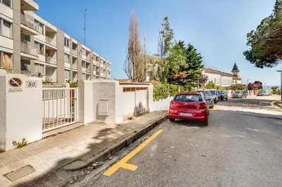 a red car parked in a parking lot next to a building at Hauzify I Apartaments Sot del Morer in San Pol de Mar