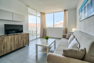 a living room with a couch and a tv at Hauzify I Apartaments Sot del Morer in San Pol de Mar