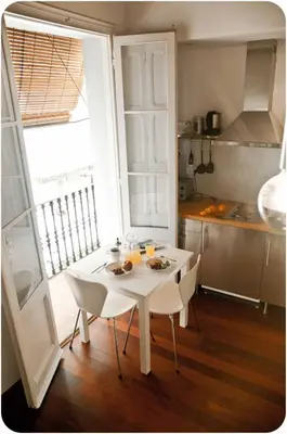 a white table and chairs in a small kitchen at Barceloneta Suites Apartments Market in Barcelona