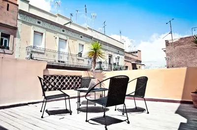 a patio with chairs and a table on a balcony at Barceloneta Suites Apartments Market in Barcelona