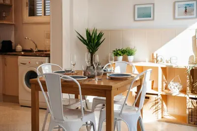 a dining room table and chairs with wine glasses on it at Sitges Holiday Apartment in Sitges