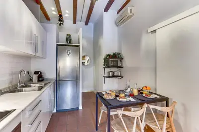 a kitchen with a table with chairs and a refrigerator at Sweett - Ausias Marc in Barcelona