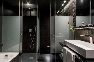 a bathroom with a shower and a sink and a tub at Hotel Bagués, a Small Luxury Hotel of the World in Barcelona