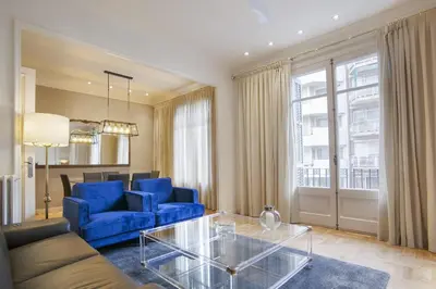 a living room with a blue couch and a glass table at Tendency Sagrada Familia Luxury in Barcelona