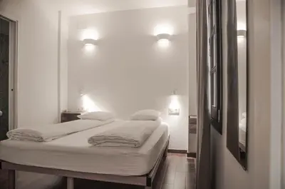 a white room with two beds and a mirror at Barcelona Beach Apartments in Barcelona