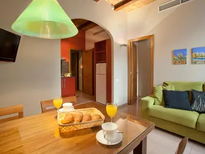 a living room with a table and a green couch at BCNGOTIC 13 in Barcelona