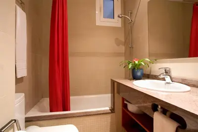 a bathroom with a sink and a red shower curtain at BCNGOTIC 13 in Barcelona