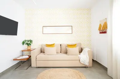 a living room with a white couch and yellow wallpaper at Ona Living Barcelona in Hospitalet de Llobregat