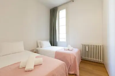 a bedroom with two beds and a window at Click&Flat Luxury Sant Joan in Barcelona
