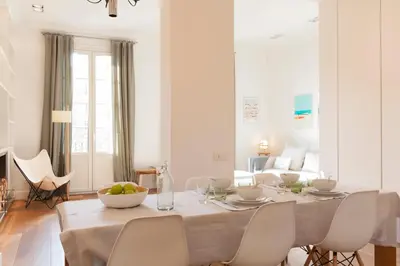 a white dining room with a table and chairs at Click&Flat Luxury Sant Joan in Barcelona