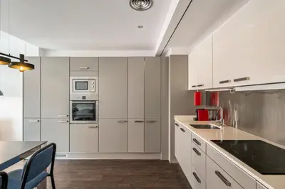 a kitchen with white cabinets and a table and chairs at Aspasios Catedral Apartments in Barcelona