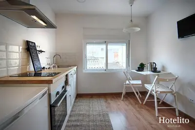 a kitchen with a sink and a table and a window at Hotelito Boutique Badalona. in Badalona