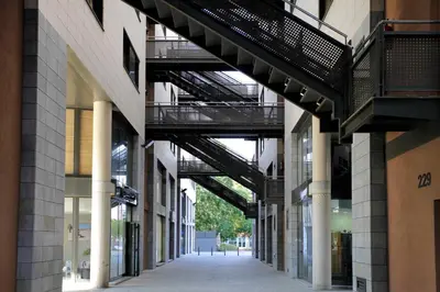 an empty alley in a building with a walkway between buildings at 1216 - Forum Gardens Apartment in Barcelona