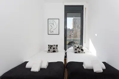 two beds in a room with a window at 1214 - TWO BEDROOMS CIUTADELLA APARTMENT in Barcelona