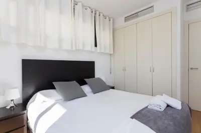 a white bedroom with a large white bed with two pillows at 1214 - TWO BEDROOMS CIUTADELLA APARTMENT in Barcelona