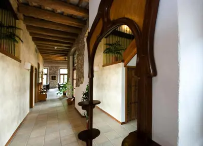 an arched hallway with wooden ceilings and a hallway with potted plants at Hotel Moli De La Torre in Bigues i Riells