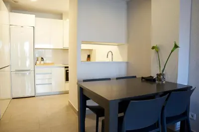 a kitchen with a table and chairs and a refrigerator at Bonavista Apartments - Virreina in Barcelona