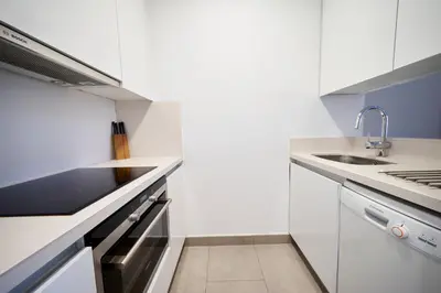 a white kitchen with a sink and a stove at Bonavista Apartments - Virreina in Barcelona