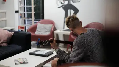 a man playing a guitar in a living room at Alternative Creative Youth Hostel Barcelona in Barcelona