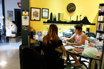 two women sitting at a table in a store at Alternative Creative Youth Hostel Barcelona in Barcelona