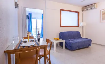 a living room with a blue couch and a table at Hola Sitges Apartments in Sitges